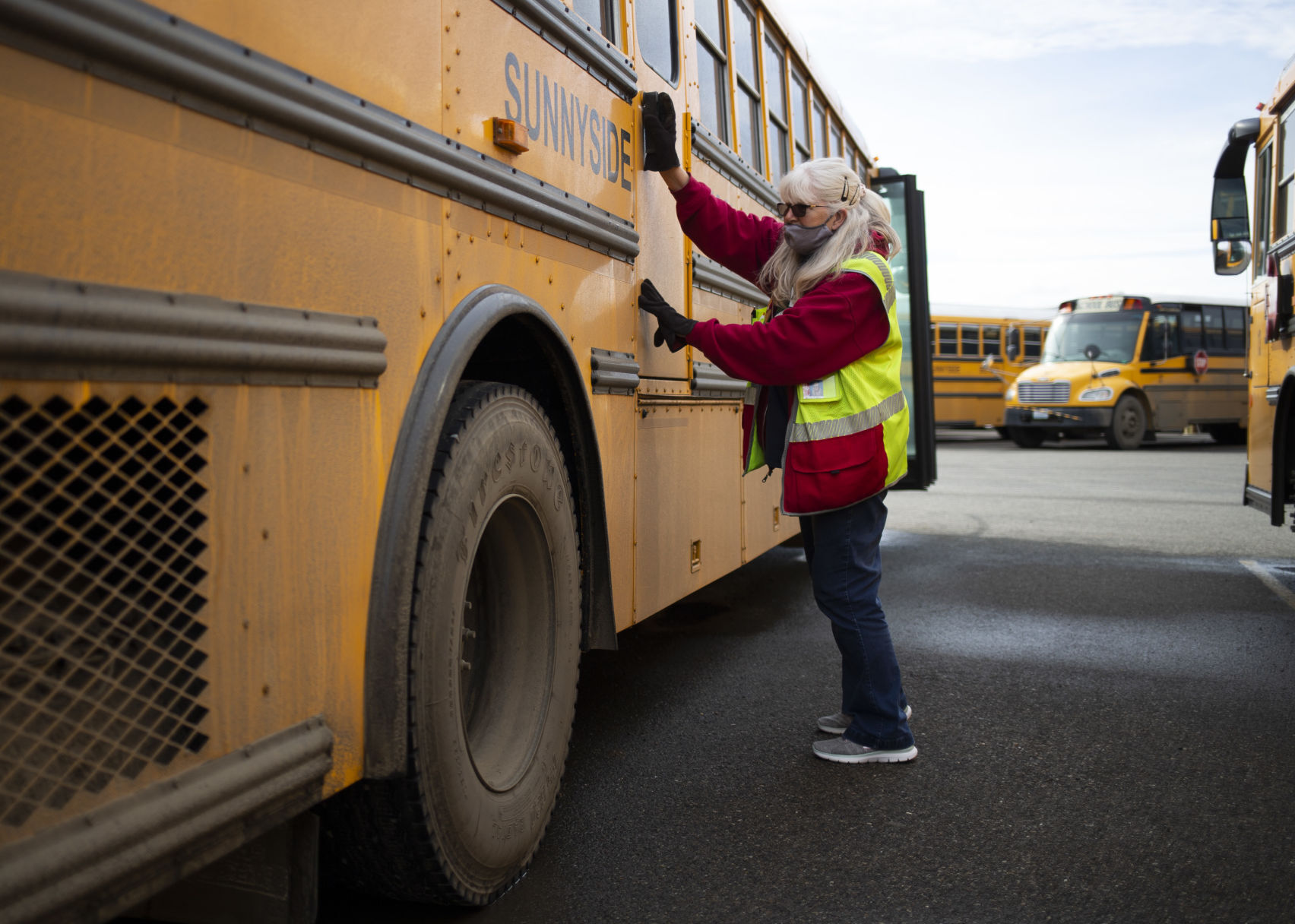 Barb Little closes the emergency exit door of her bus